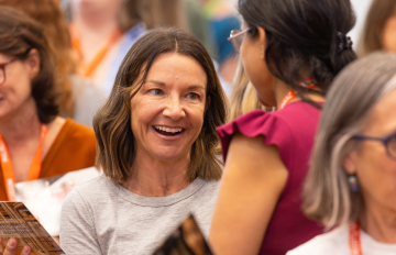 A woman smiles at a conference